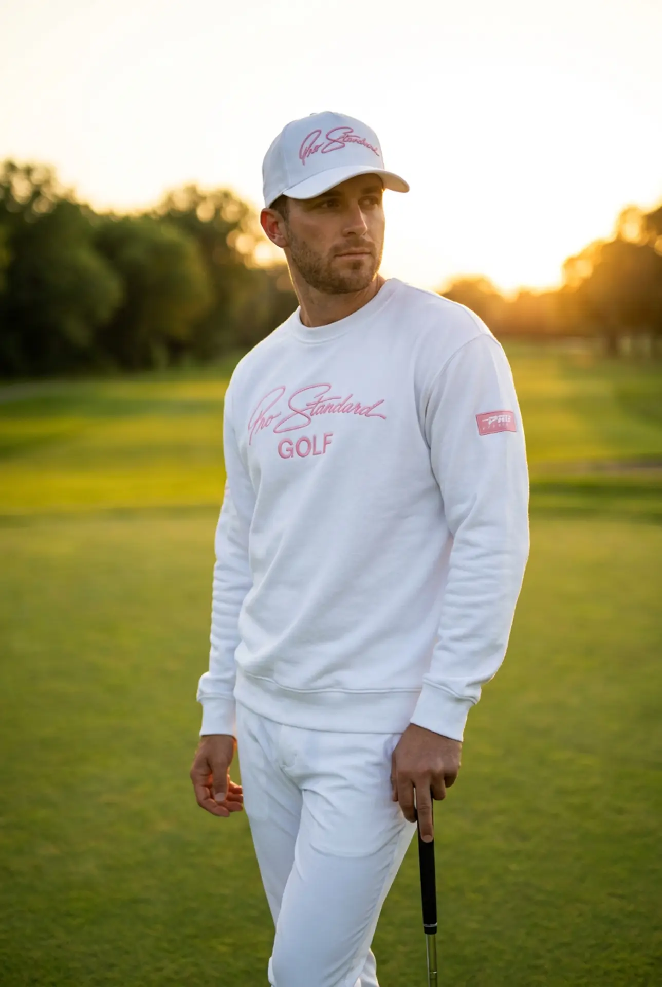 Model in the white Pro Standard Golf crewneck and pants at sunset